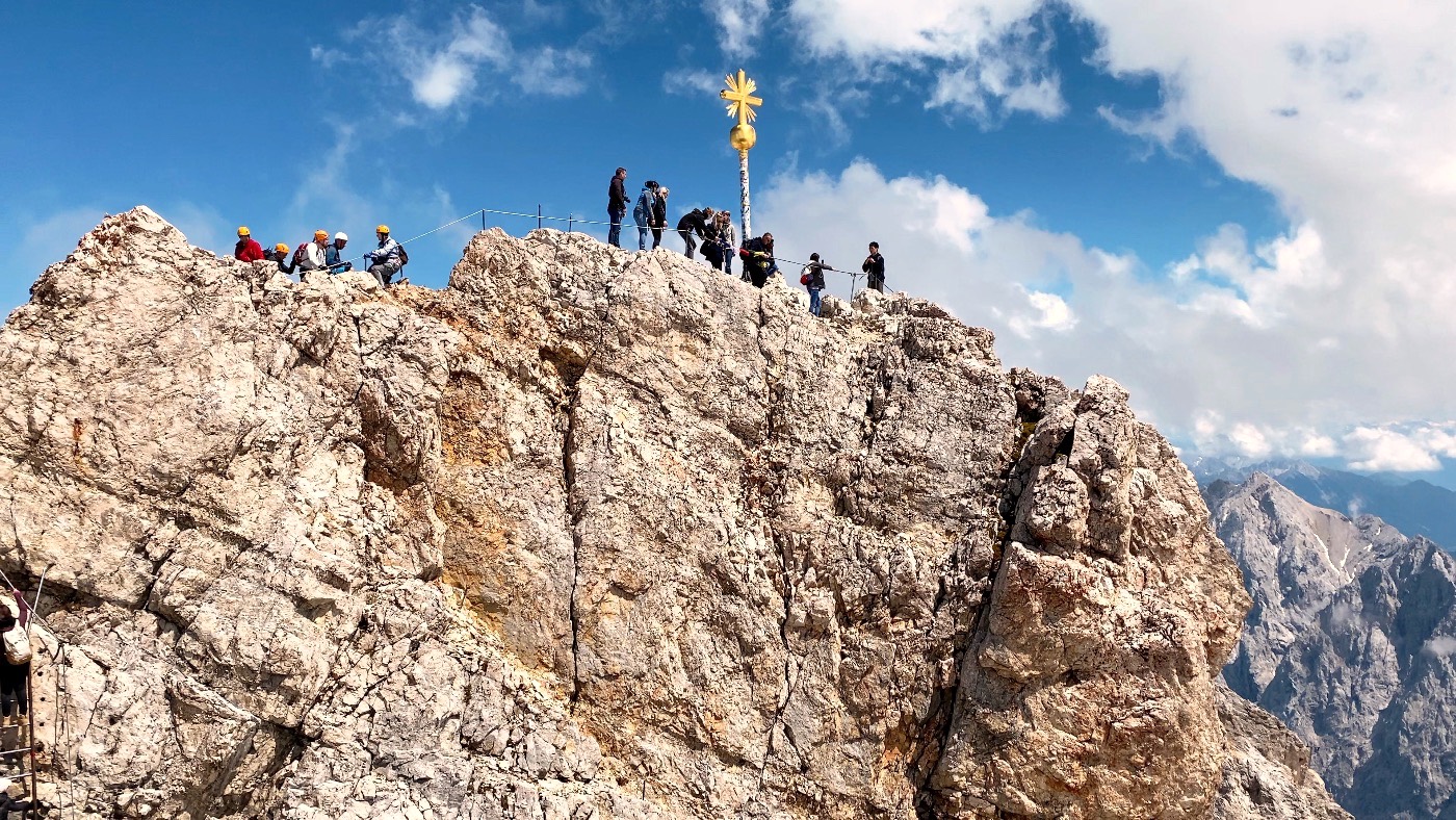 Visitors gathered around the golden summit cross of the Zugspitze