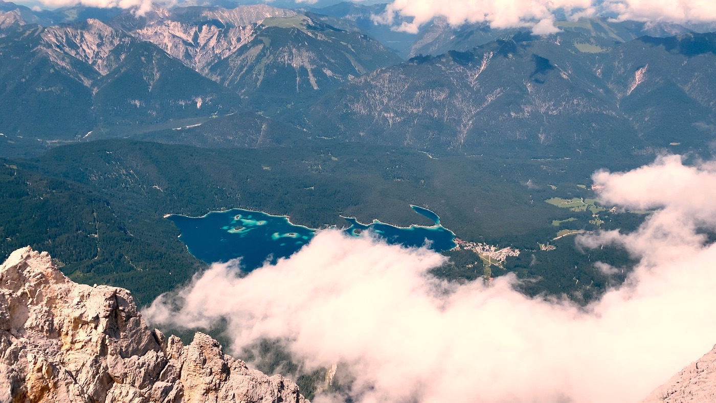 An aerial view of the deep-blue Eibsee far below the Zugspitze summit