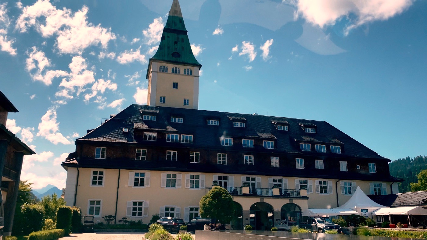 The grand turreted facade of Schloss Elmau against the Alps