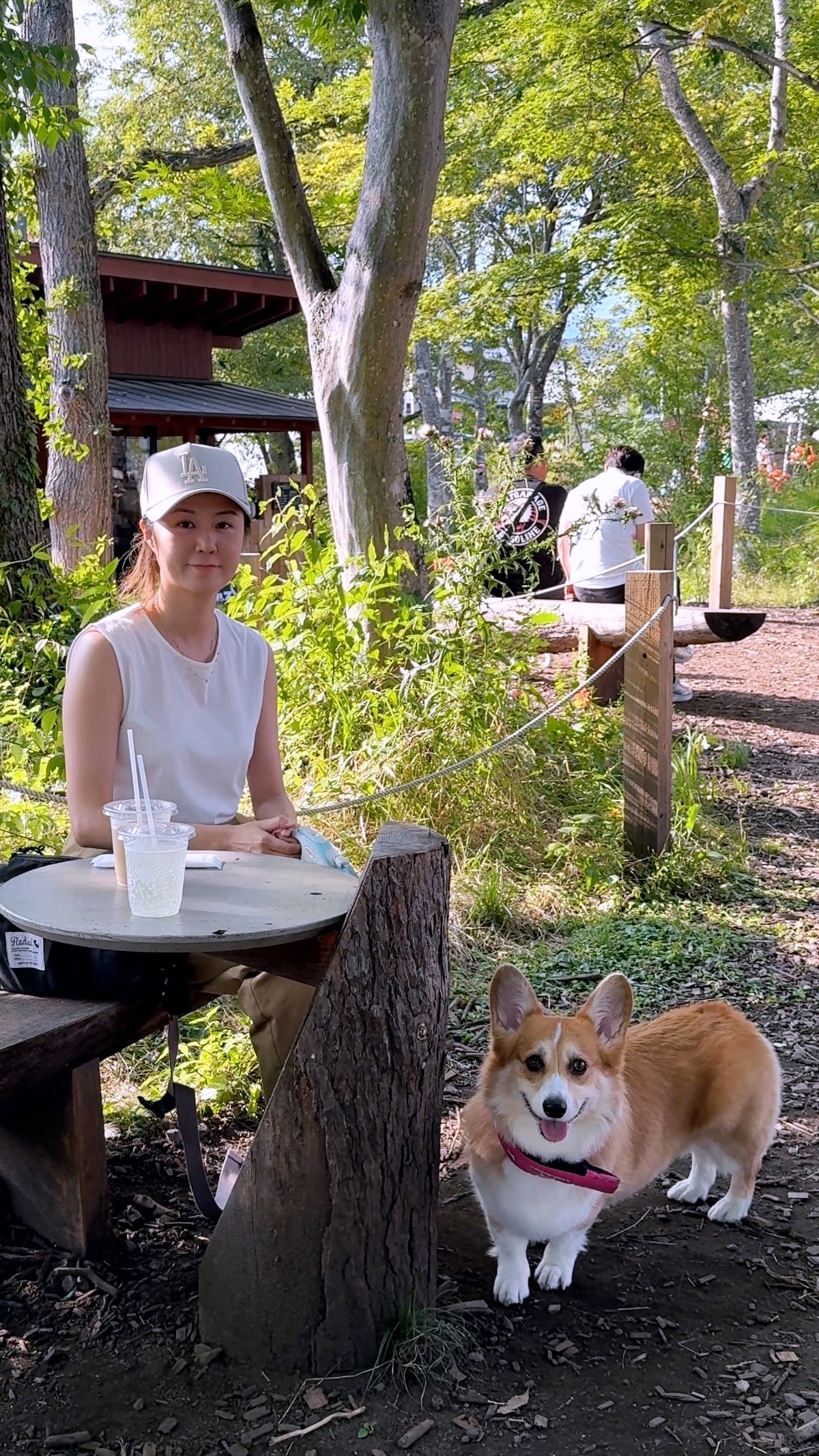 The owner and Scottie at an outdoor park café among the trees