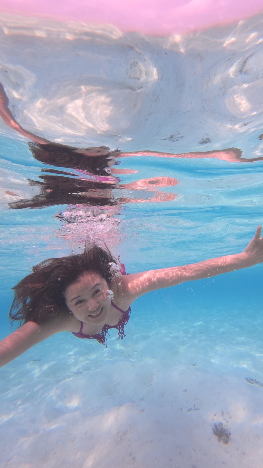 Swimming underwater in the clear Maldives lagoon at sunset