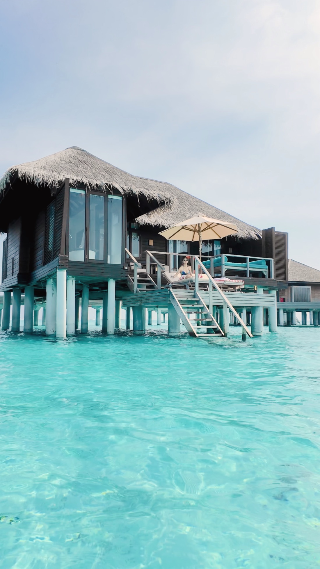 An overwater villa on stilts above the turquoise Maldives lagoon